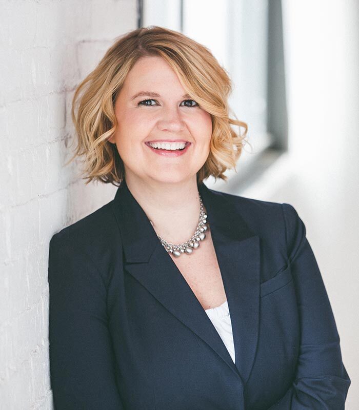 About Our Agency - Smiling Businesswoman Helping Clients at Her Desk
